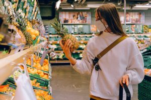 Woman holding a pineapple in a supermarket 